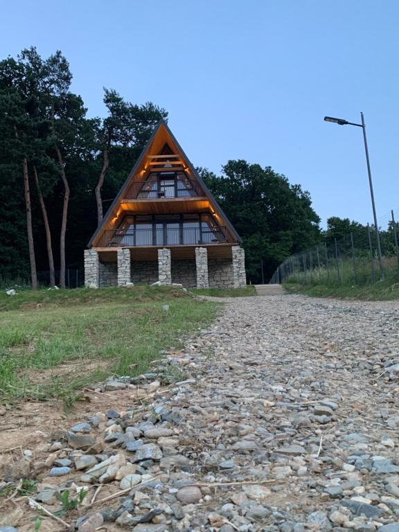 una casa con il tetto di paglia su una strada rocciosa di Cabana Icas a Dej