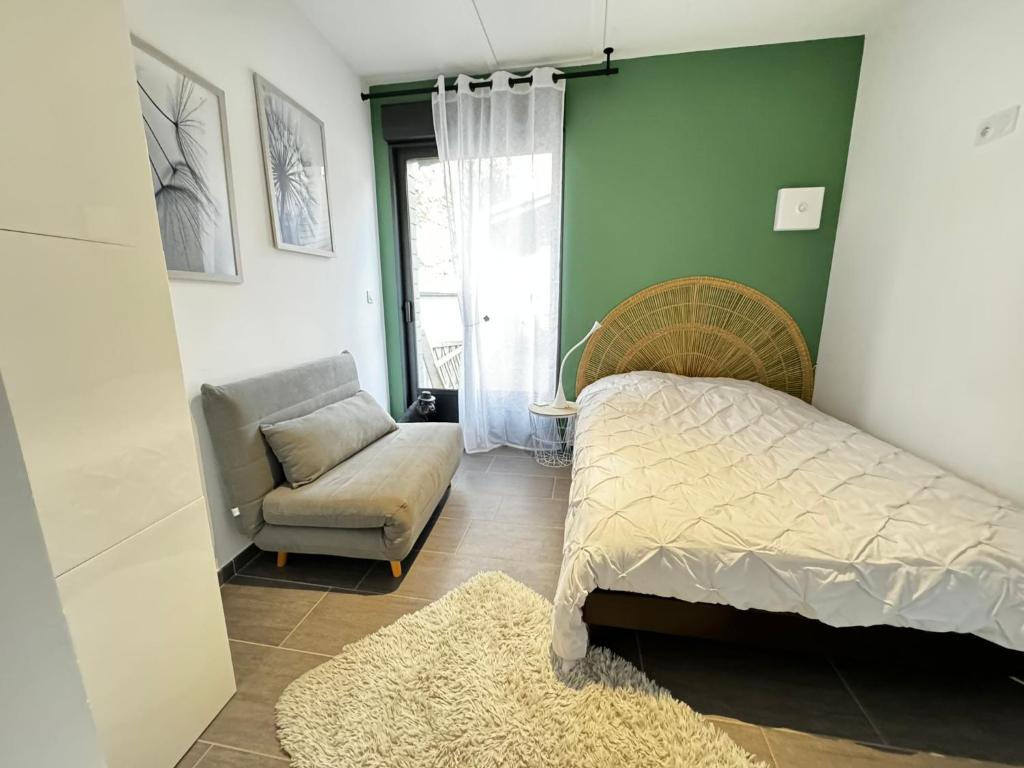 une chambre avec un lit, une chaise et une fenêtre dans l'établissement Studio indépendant et cosy, à Basse-Goulaine
