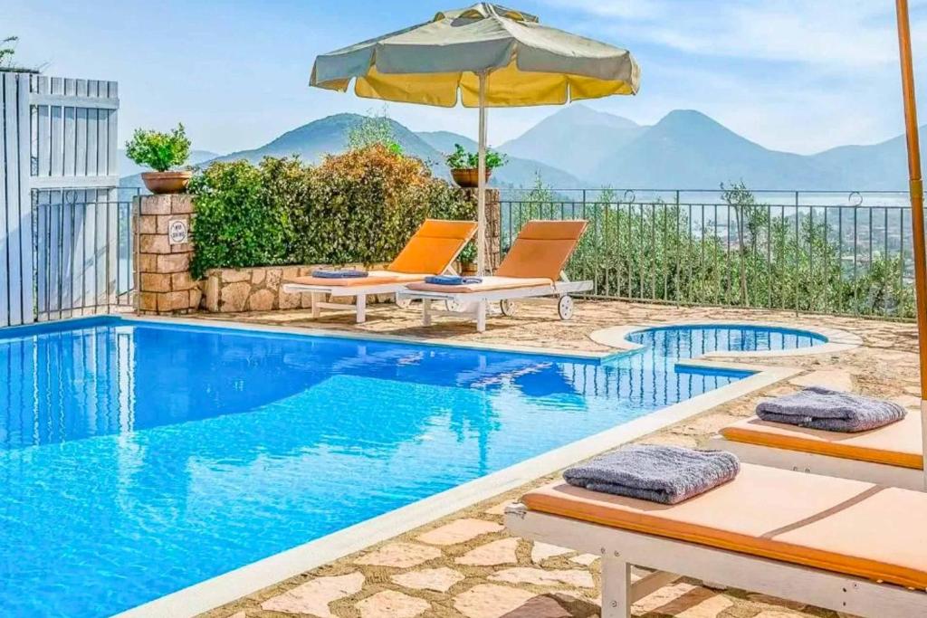 una piscina con due sedie e un ombrellone di Villa Adriani a Nydri