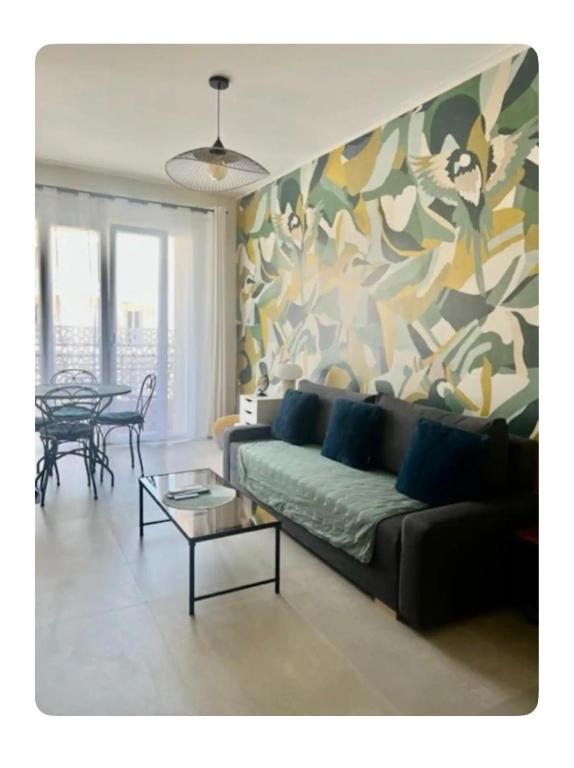 - un salon avec un canapé et un tableau dans l'établissement Tout équipé et rénové à neuf, au Cannet