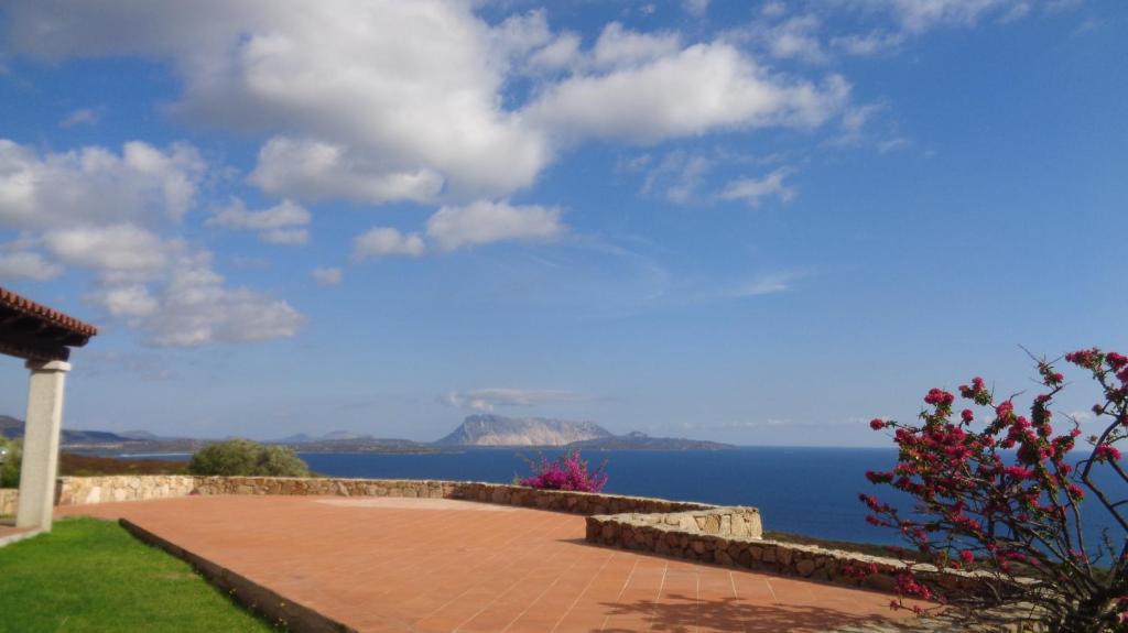 een stenen loopbrug met uitzicht op de oceaan bij Villino Caddu in San Teodoro