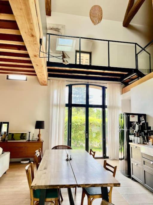 une cuisine avec une table et des chaises dans une pièce dans l'établissement L' Authentique - Longère de caractère rénovée, à Vault-de-Lugny