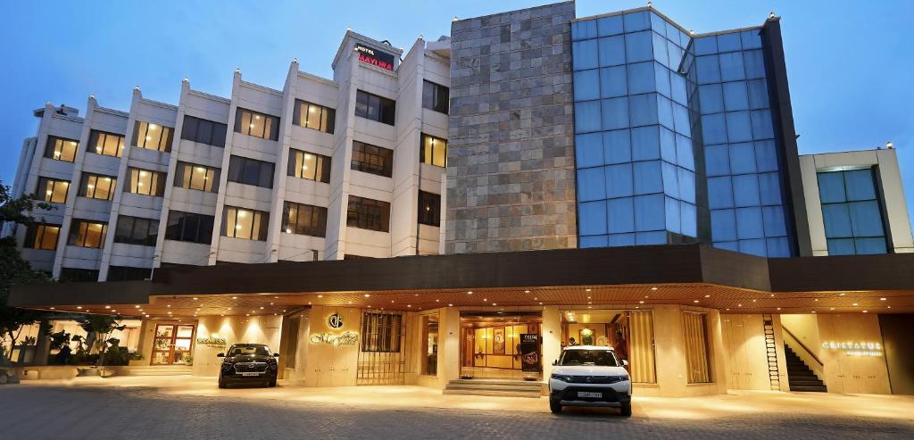 a building with a car parked in front of it at Hotel Mayura in Raipur