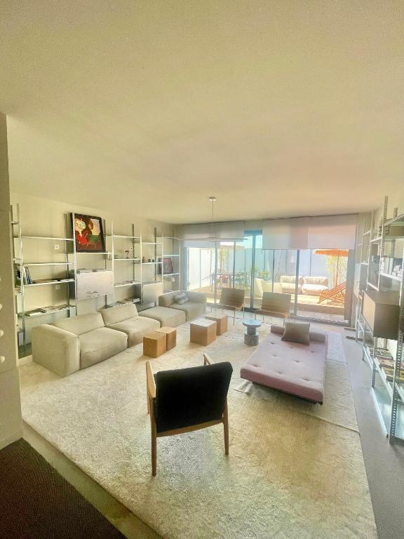 un grand salon avec un canapé et une table dans l'établissement Appartement style Loft quartier Saint-Augustin Bordeaux, à Bordeaux