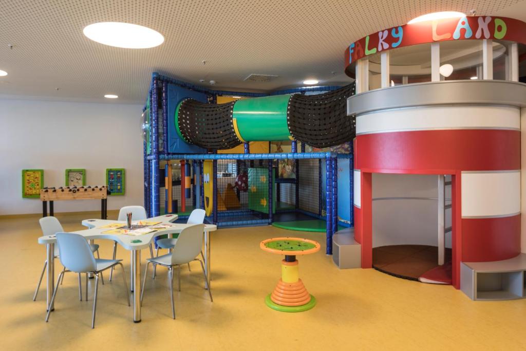 a play room with a table and chairs and a water slide at Falkensteiner Hotel Park Punat in Punat
