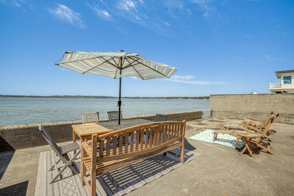 un patio avec une table, un parasol et des chaises dans l'établissement Oceanfront Cottage with Patio and Views in Birch Bay!, à Blaine