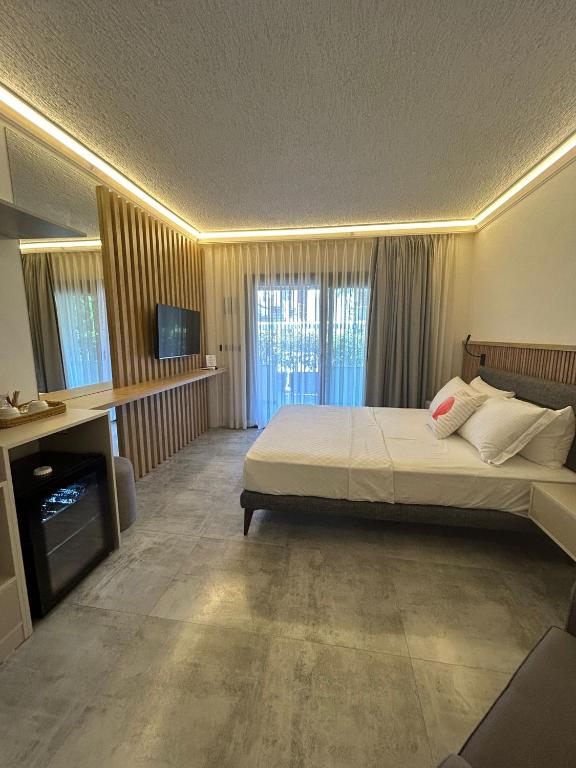 a bedroom with a large bed and a television at Naz Liman Otel Bodrum in Bodrum City