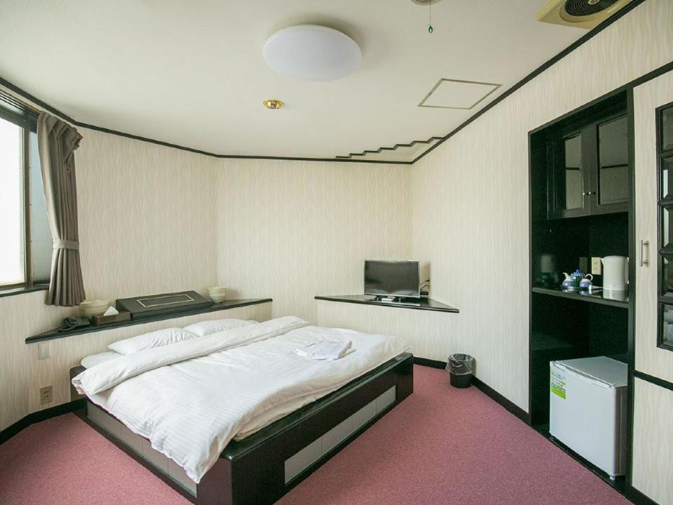 Postel nebo postele na pokoji v ubytování 大阪グランドホテルアネックス