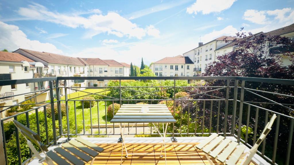 een balkon met een tafel en banken bij Le Jardin Suspendu, Steps to Lake & Station in Bussy-Saint-Georges