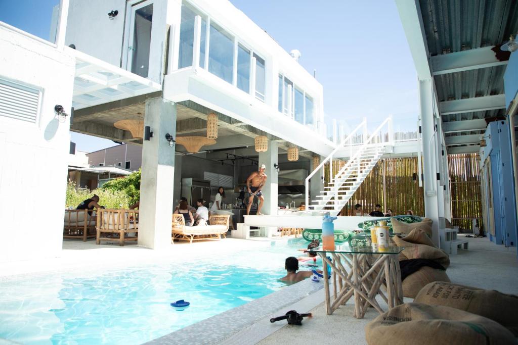 a pool at a hotel with people sitting around it at Travel Light Bubble Diving Center in Xiaoliuqiu