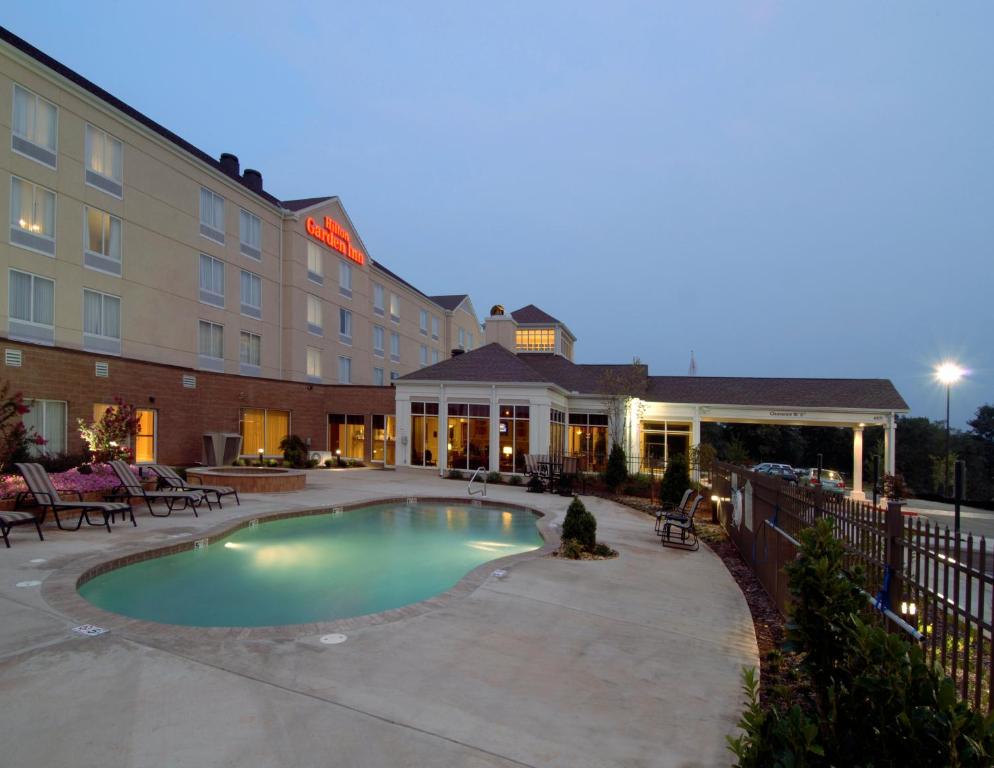 a hotel with a pool in front of a building at Hilton Garden Inn Huntsville/Space Center in Huntsville