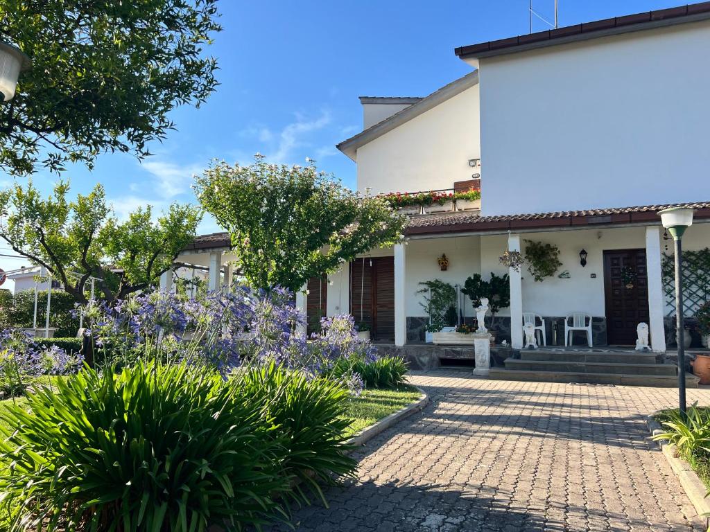 Una casa con flores moradas en el frente. en Giardino Degli Aranci B&B, en Ponte Galeria