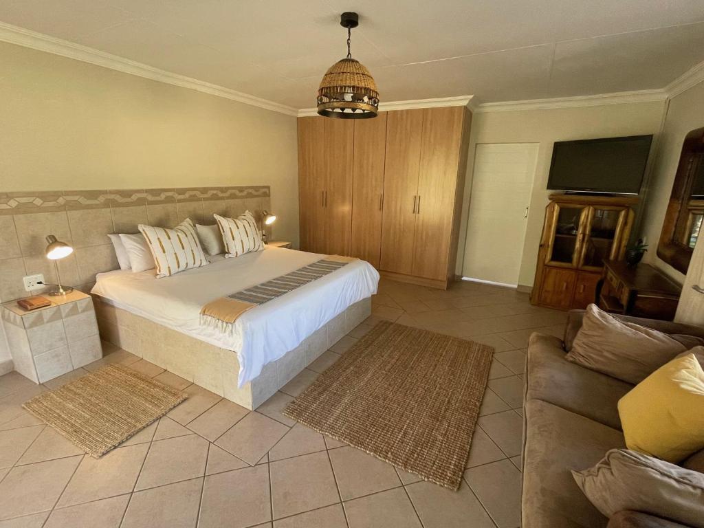 a bedroom with a large bed and a couch at Zomoya Game Farm in Vaalwater