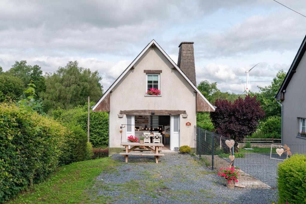 een wit huis met een picknicktafel ervoor bij Gite Au Chant d'Eole in Ebly