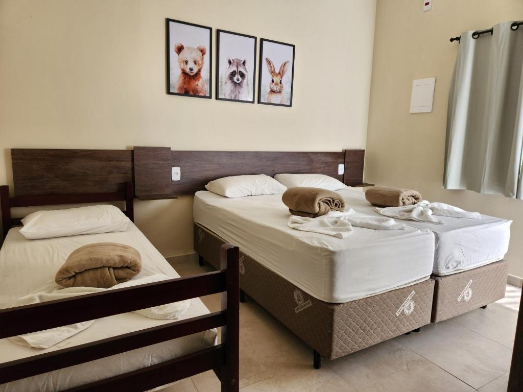 two twin beds in a room with at O Franciscano Hospedagem in Cachoeira Paulista