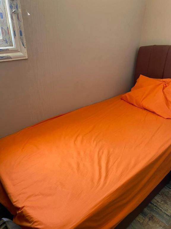 a bed with an orange sheet on top of it at بورتو مارينا ريزدنس in El Alamein