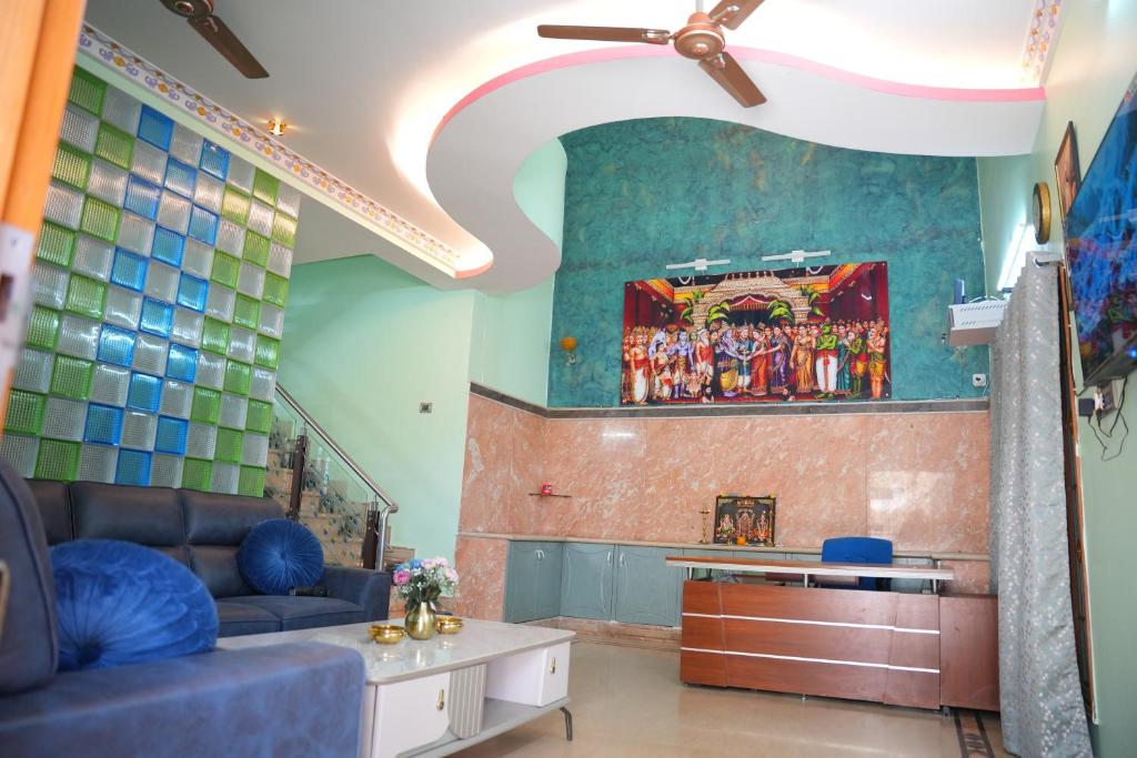 a living room with a couch and a painting on the wall at The HR STAY INN TIRUPATI - LUXURY HOMESTAY - NEAR ALIPIRI BUS STAND AND KAPILATEERTHAM - 24 HRS HOT WATER-150 MBPS SPEED FREE WIFI & ALL OTT APPS in Tirupati