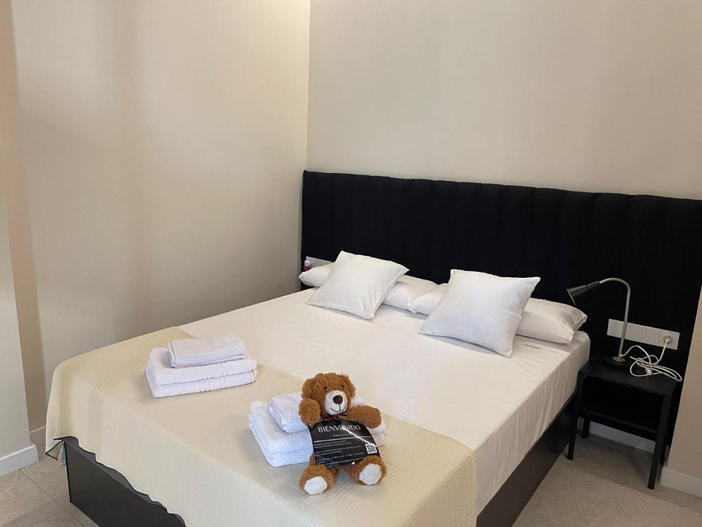 un orsacchiotto seduto su un letto con asciugamani di Osito Hub - Campoamor a Valencia