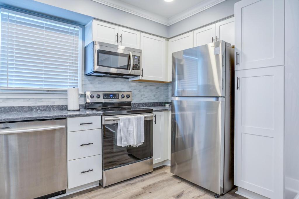a kitchen with white cabinets and a stainless steel refrigerator at Hilton Head Resort 1424 in Hilton Head Island