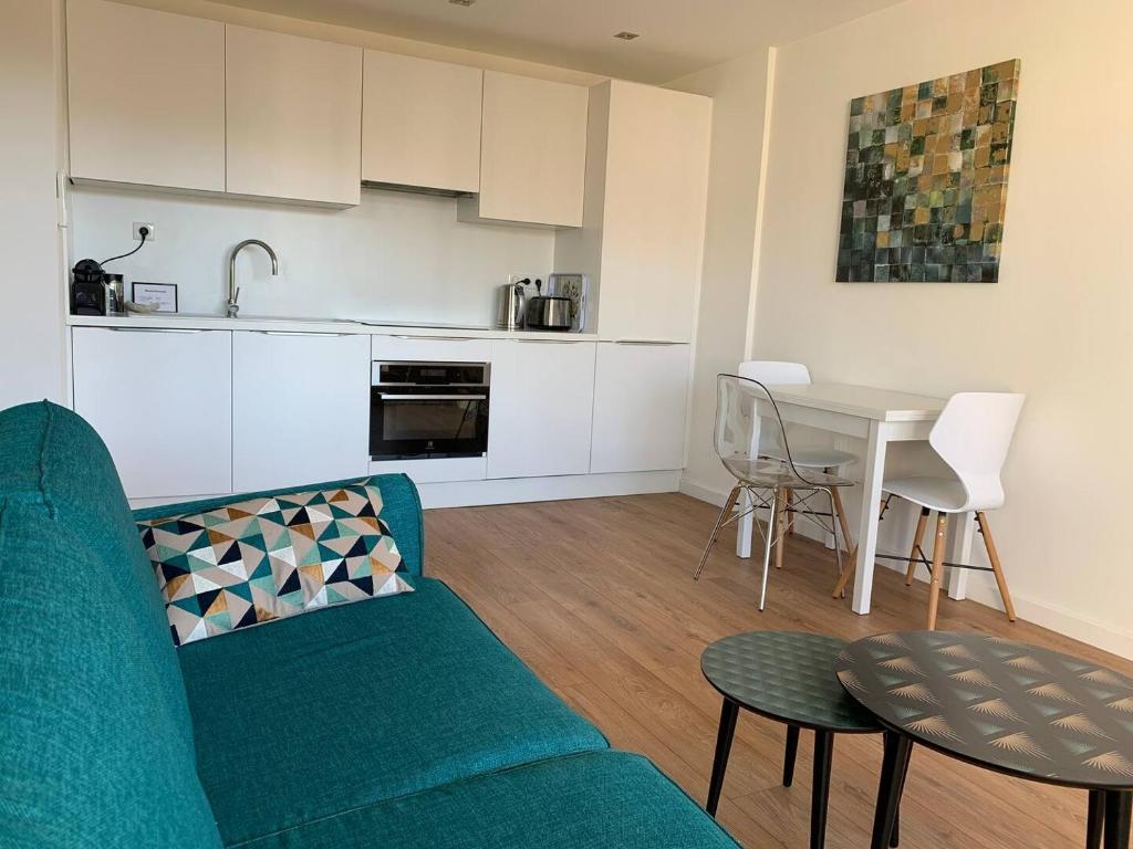 un salon avec un canapé bleu et une table dans l'établissement Two bedroom apartment Rouaze, à Cannes