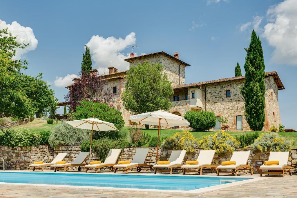 un grupo de sillas y sombrillas junto a una piscina en Villa Il Cerretaccio, en Monti di Sotto