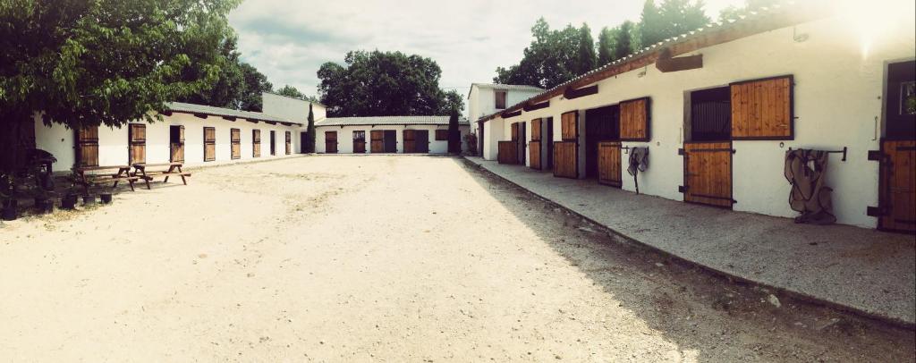 une cour vide avec un tas de bâtiments dans l'établissement Maison au milieu des chevaux, à LʼIsle-sur-la-Sorgue