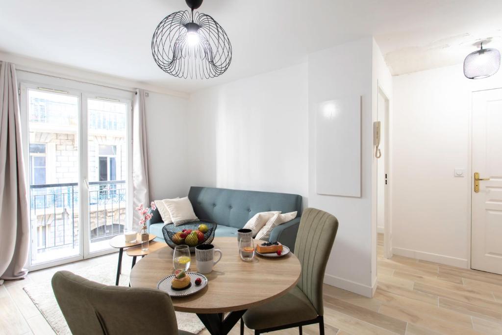 un salon avec une table et un canapé dans l'établissement #58 Logement Clim & Balcon 5mins marche de la Mer, à Nice