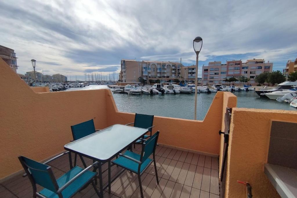 un balcon avec une table et des chaises et un port de plaisance dans l'établissement A balcony overlooking the marina, à Frontignan