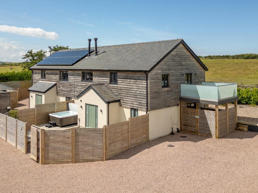 a house with a fence in front of it at Farmyard House in Amlwch
