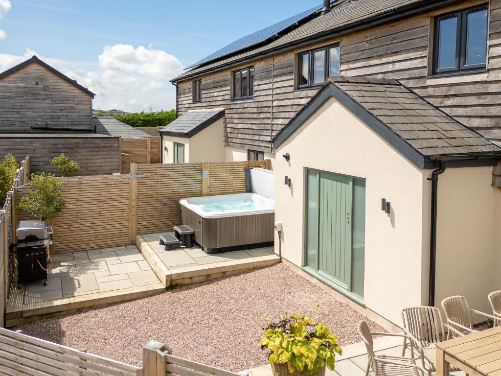 a backyard with a hot tub and a house at Farmyard House in Amlwch