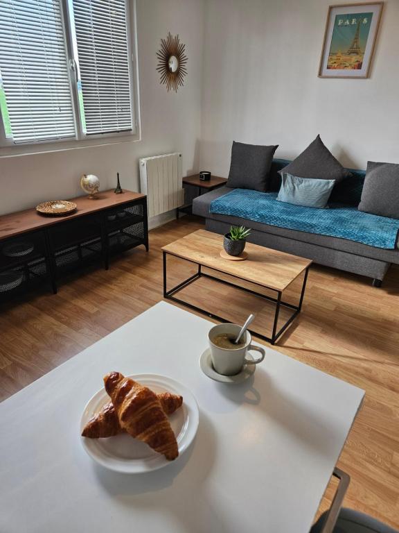 - un salon avec une table et une assiette de pain dans l'établissement Studio cozy proche Versailles, à Toussus-le-Noble