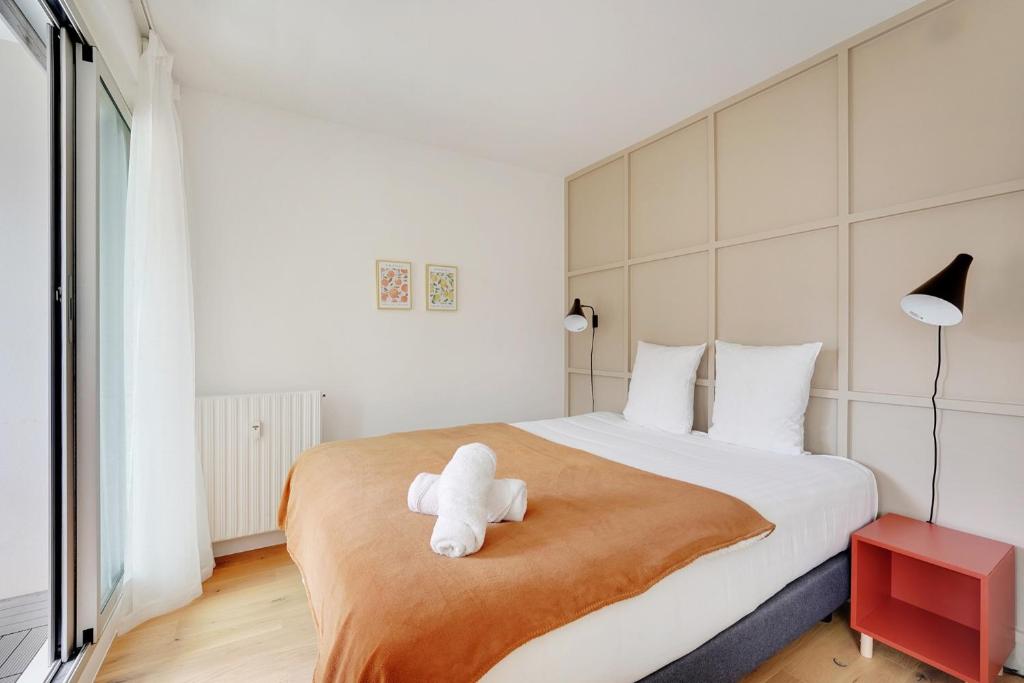 un ours en peluche blanc assis au-dessus d'un lit dans l'établissement Bel appartement design proche Gare de Lyon, balcon, à Paris