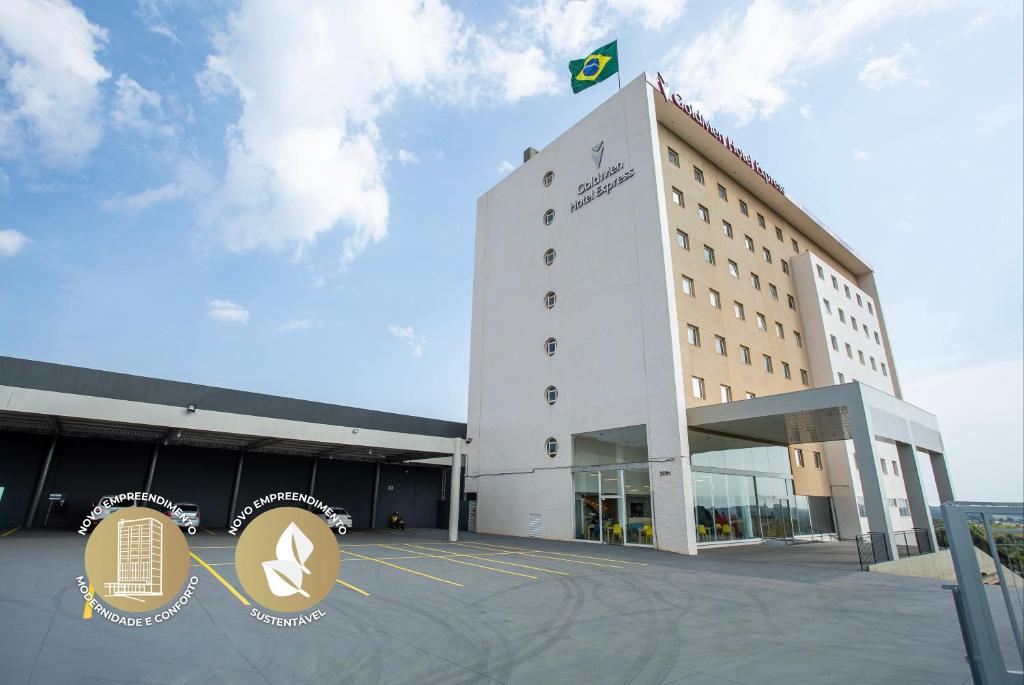 Un gran edificio con una bandera encima. en GoldMen Express Cianorte, en Cianorte