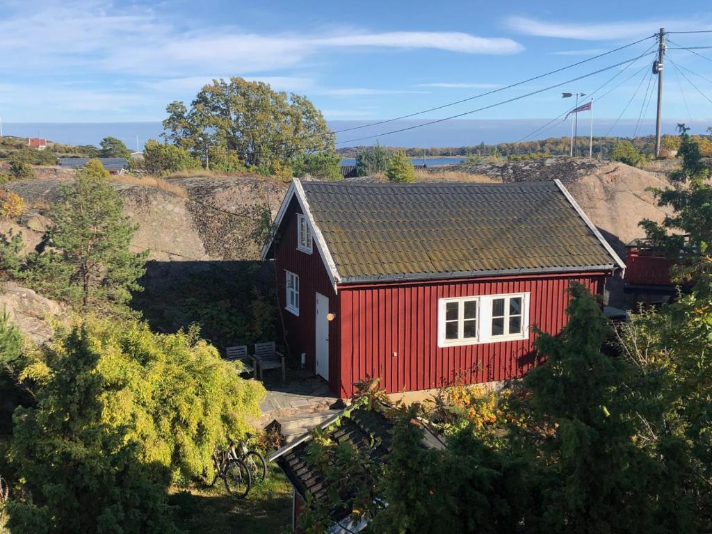 a red house with a white window in a field at Guest House in Tjøme