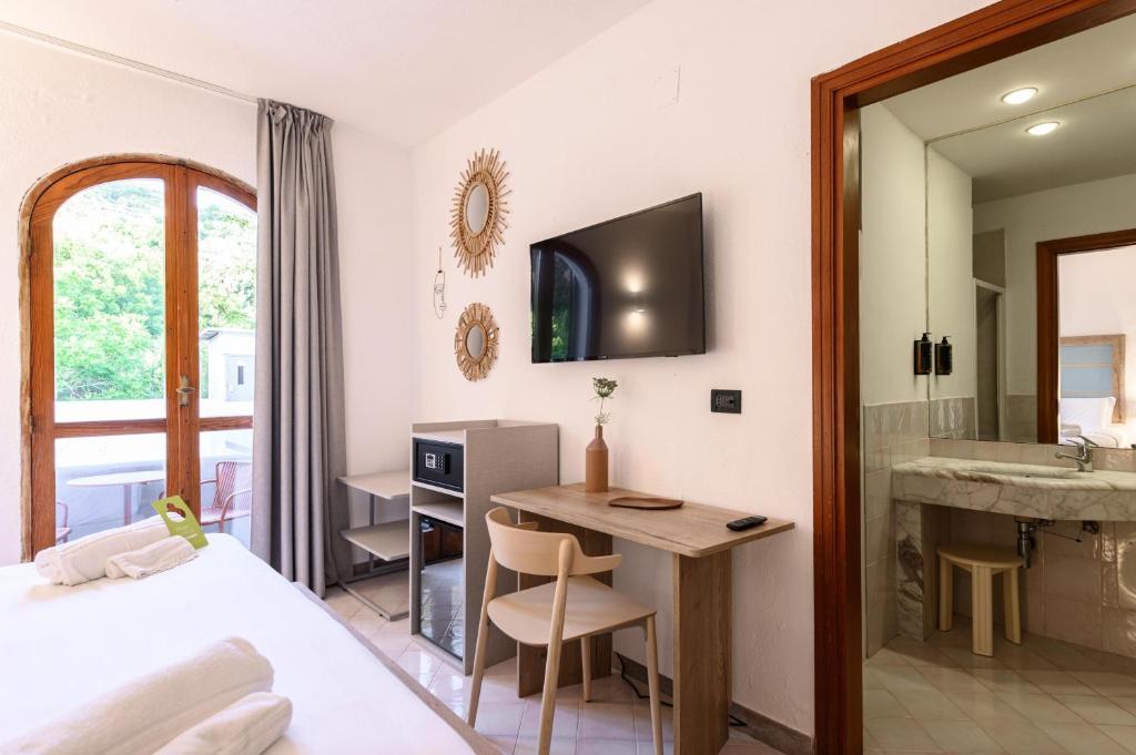 イスキアにあるB&B HOTEL Ischia San Nicolaのベッドルーム1室(ベッド1台、デスク、シンク付)