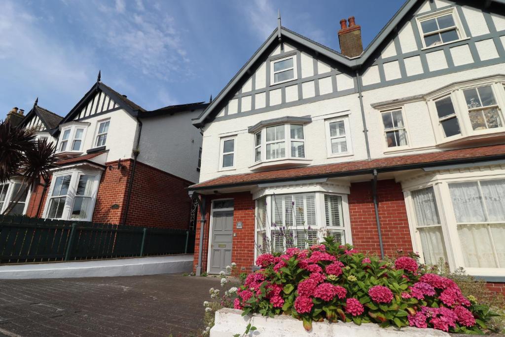 a white and red house with flowers in front of it at Wagtails in Whitby