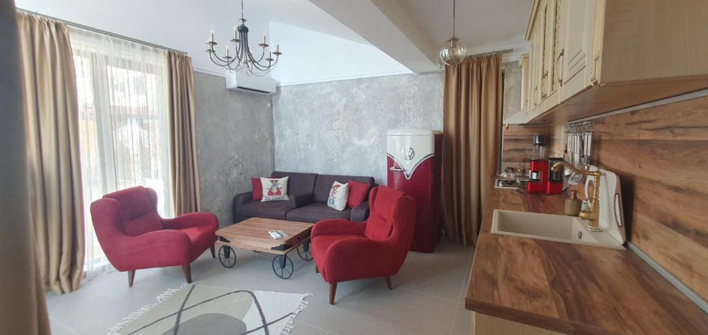 ソゾポルにあるАпартамент Злато изглед МОРЕのリビングルーム(ソファ、赤い椅子2脚付)