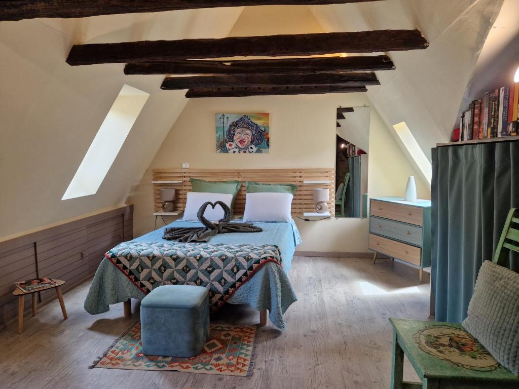 - une chambre avec un lit doté d'une ottomane bleue dans l'établissement Les Flamboyants, à Sarlat-la-Canéda