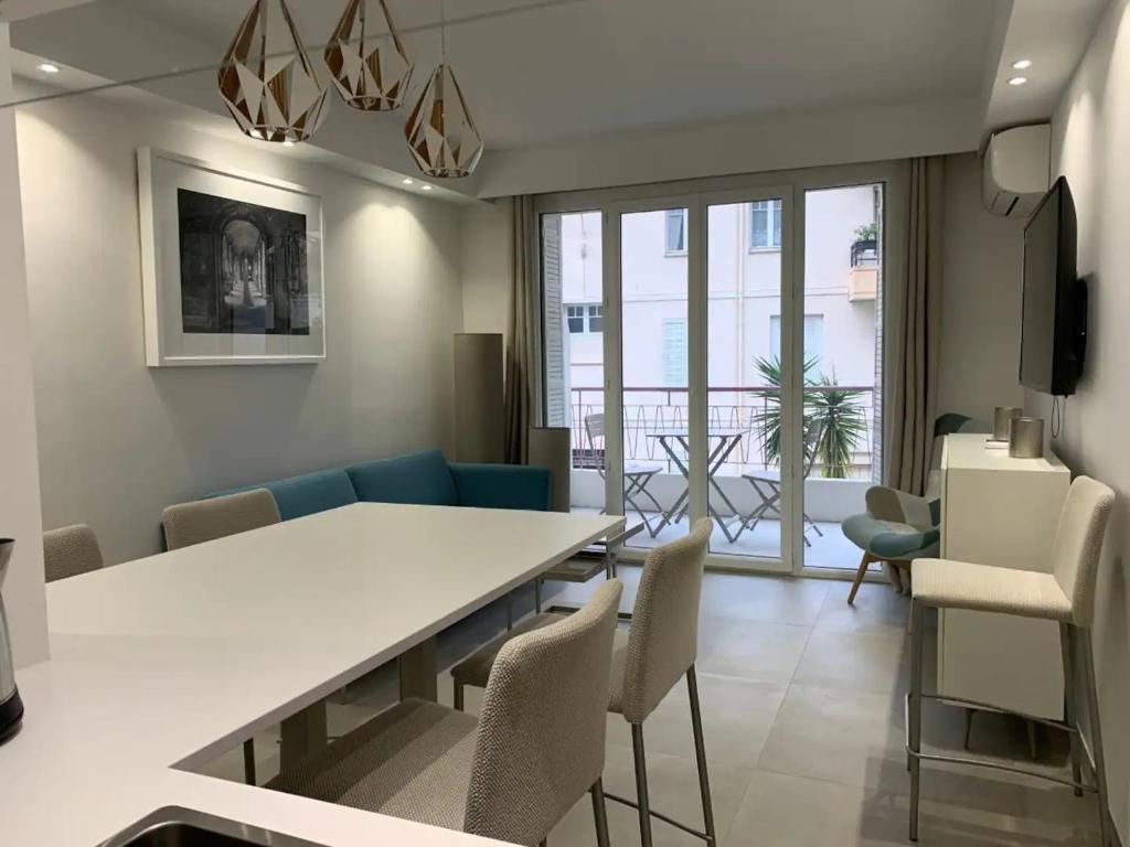 un salon avec une table et des chaises de salle à manger dans l'établissement Two bedroom Fragonard Cannes, à Cannes