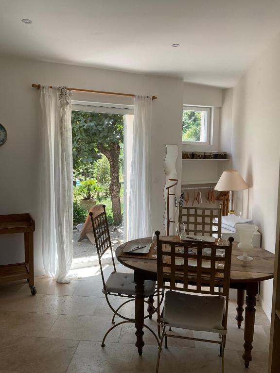 une salle à manger avec une table et des chaises et une fenêtre dans l'établissement Studio lumineux, à Villeneuve-lès-Avignon