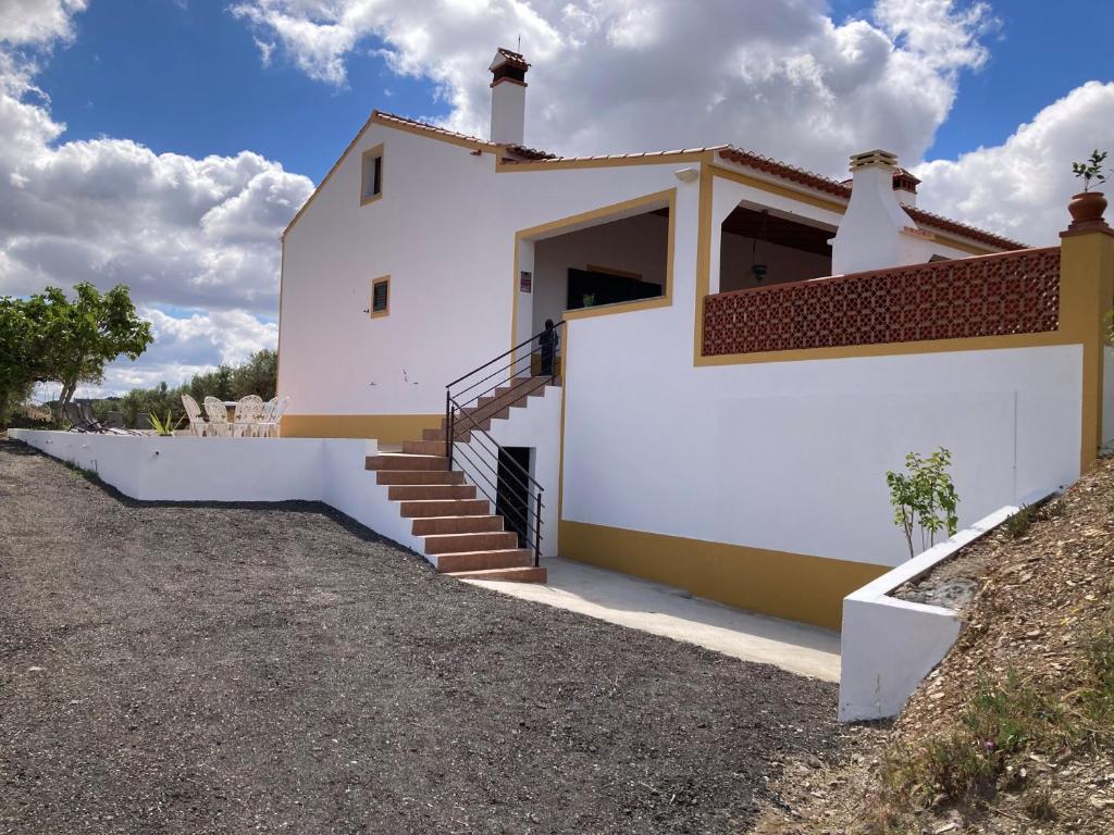 una casa bianca con una scala di fronte di Quinta Monte da Azinheira a Amareleja