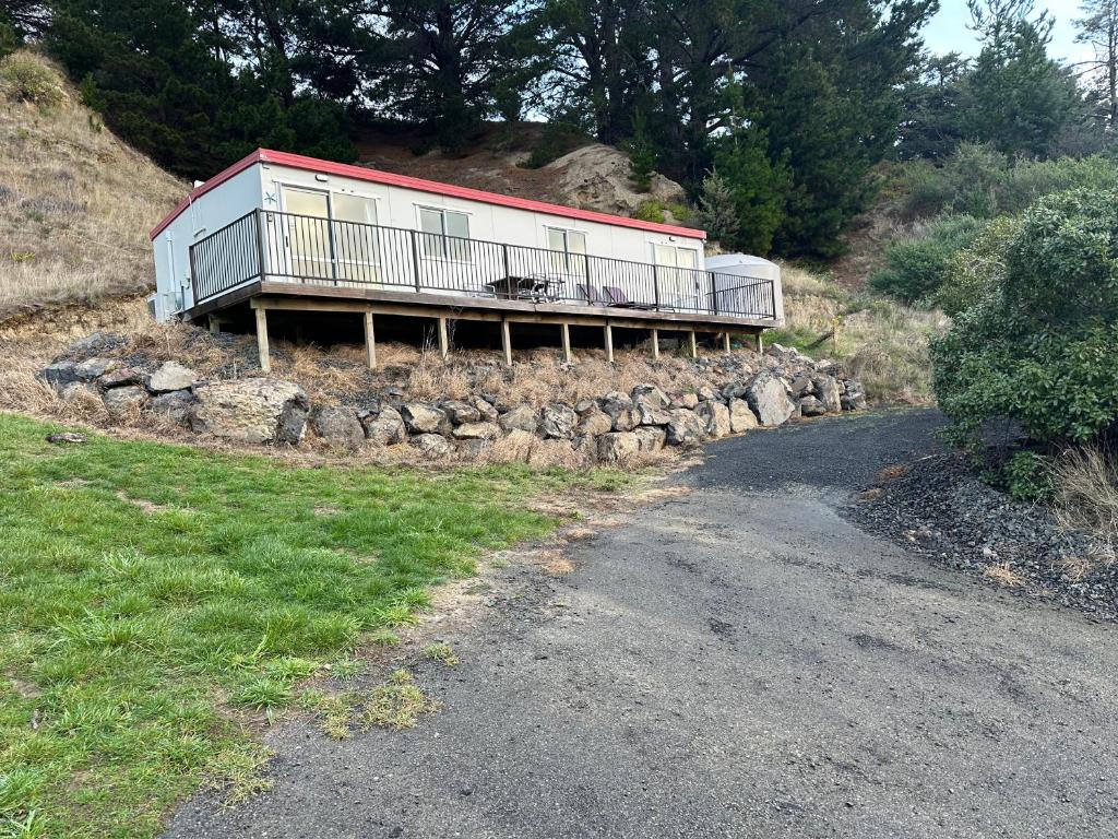een huis aan de zijkant van een heuvel naast een weg bij Lushingtons Bay - Takamatua in Akaroa