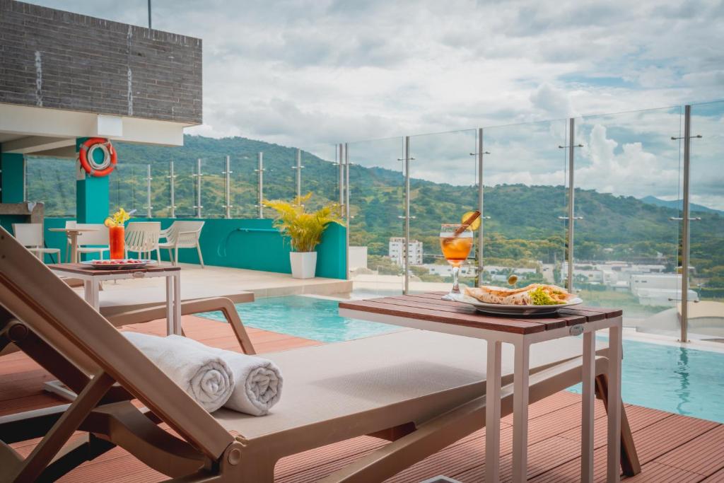 Una habitación con una piscina y una mesa con un plato de comida. en Holiday Inn Express Yopal by IHG, en Yopal
