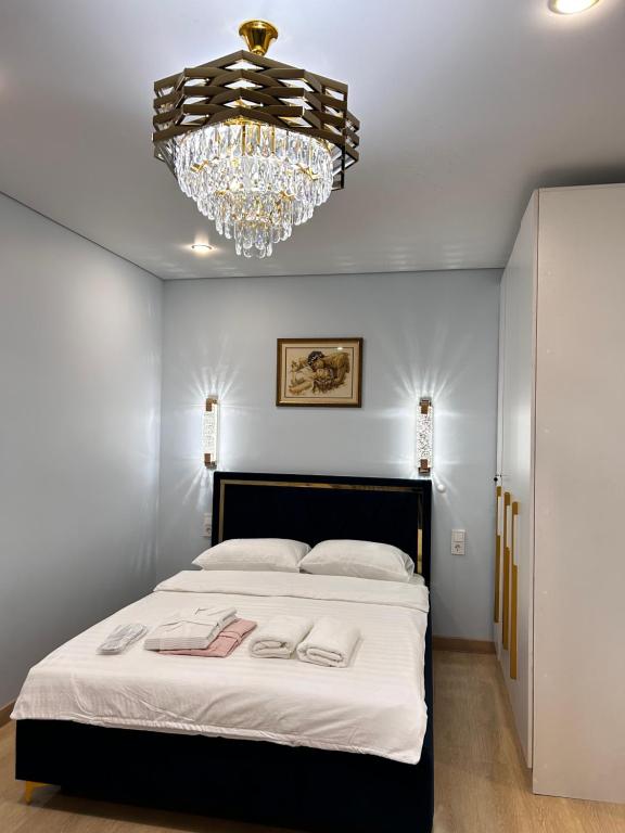 Un dormitorio con una cama grande con una lámpara de araña. en Квартира на Тимирязева 58 Luxury Central, en Almaty