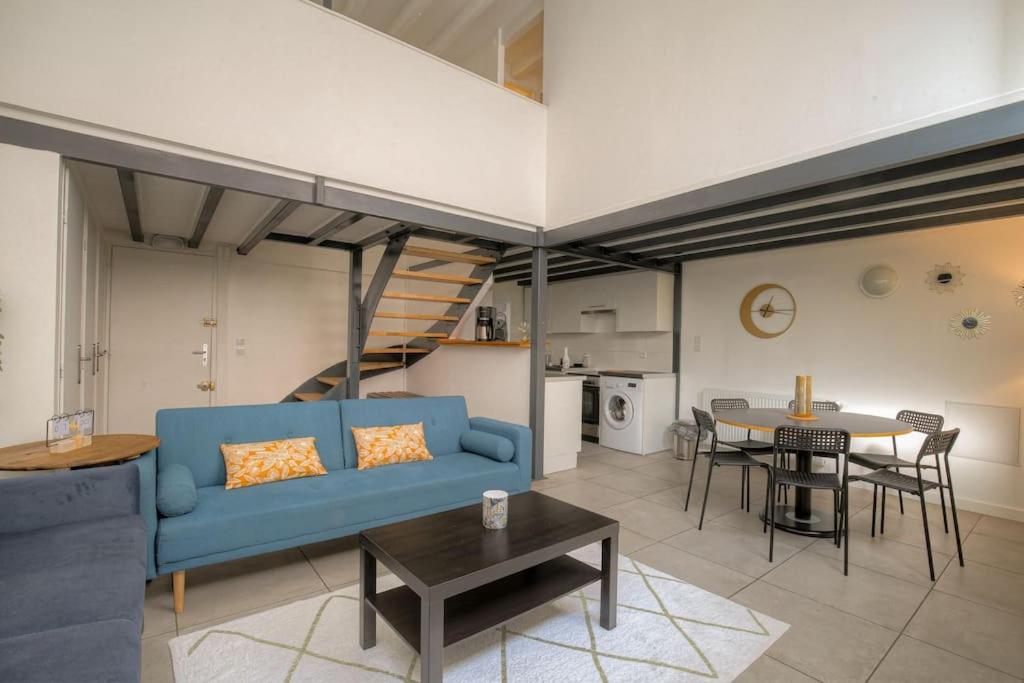 un salon avec un canapé bleu et une table dans l'établissement Appartement spacieux, proche gare, Lyon 3e, à Lyon