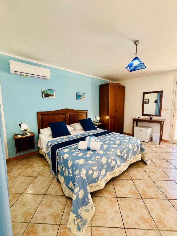a bedroom with a large bed with blue walls at Hotel Giglio in Lampedusa