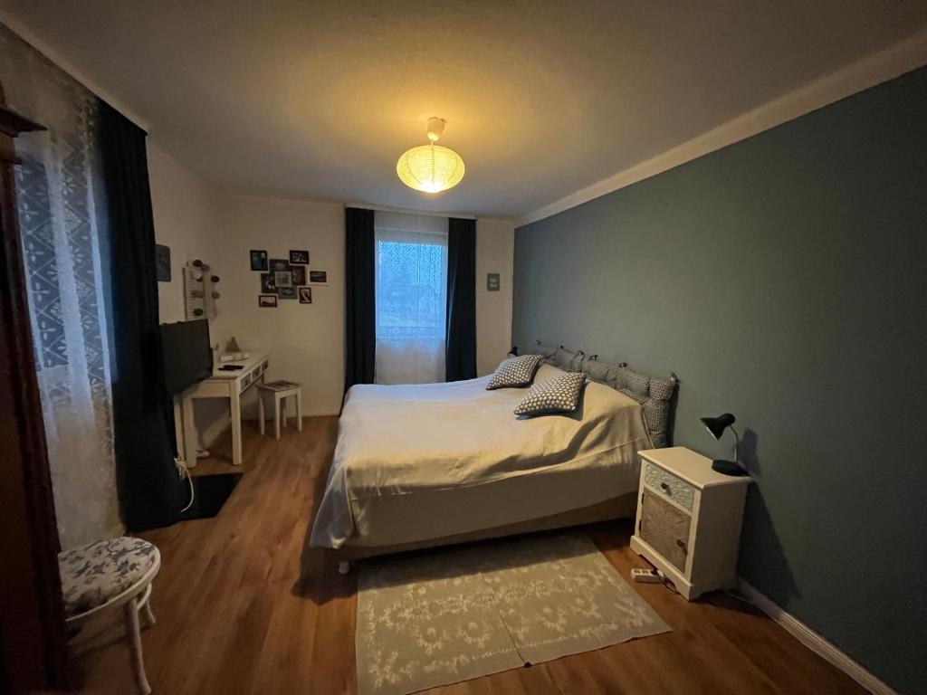 a bedroom with a bed and a table and a window at Ferienwohnung 1 Klangweberei im Frankenwald in Helmbrechts