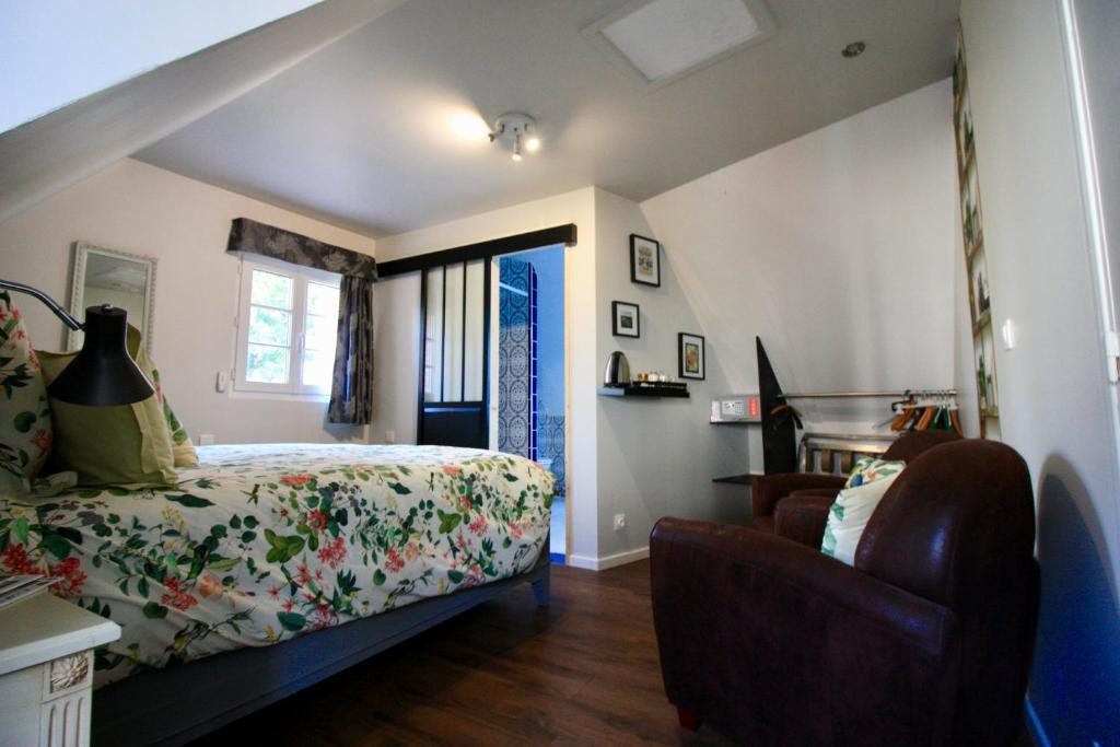 a bedroom with a bed and a chair and a window at Aggarthi Bed and Breakfast in Bayeux