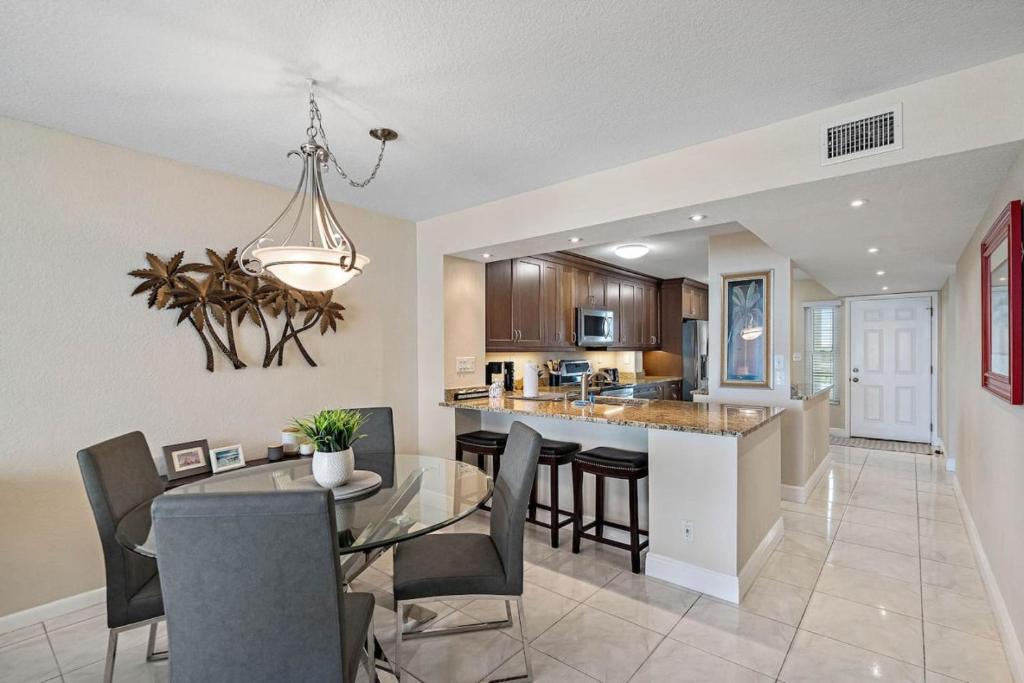 Un comedor y una cocina con una mesa de cristal y sillas. en New Listing Bahia Vista 8 411 2BD 2BA, en Tierra Verde
