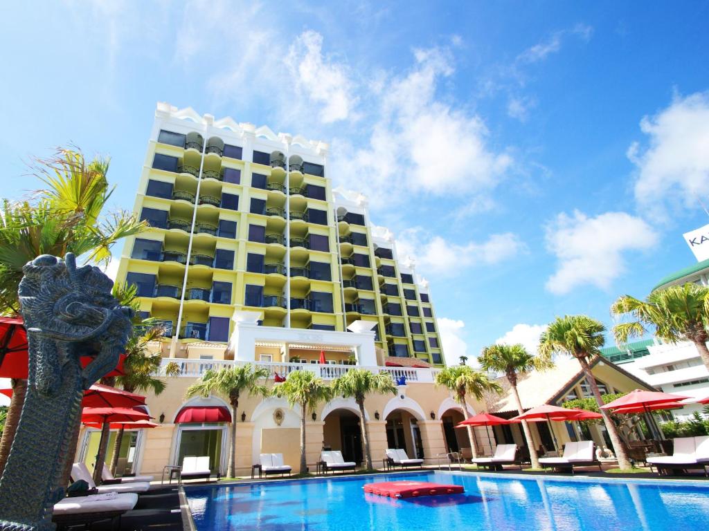 恩納村にある沖縄かりゆしリゾートEXES恩納の建物の前にスイミングプールがあるホテル